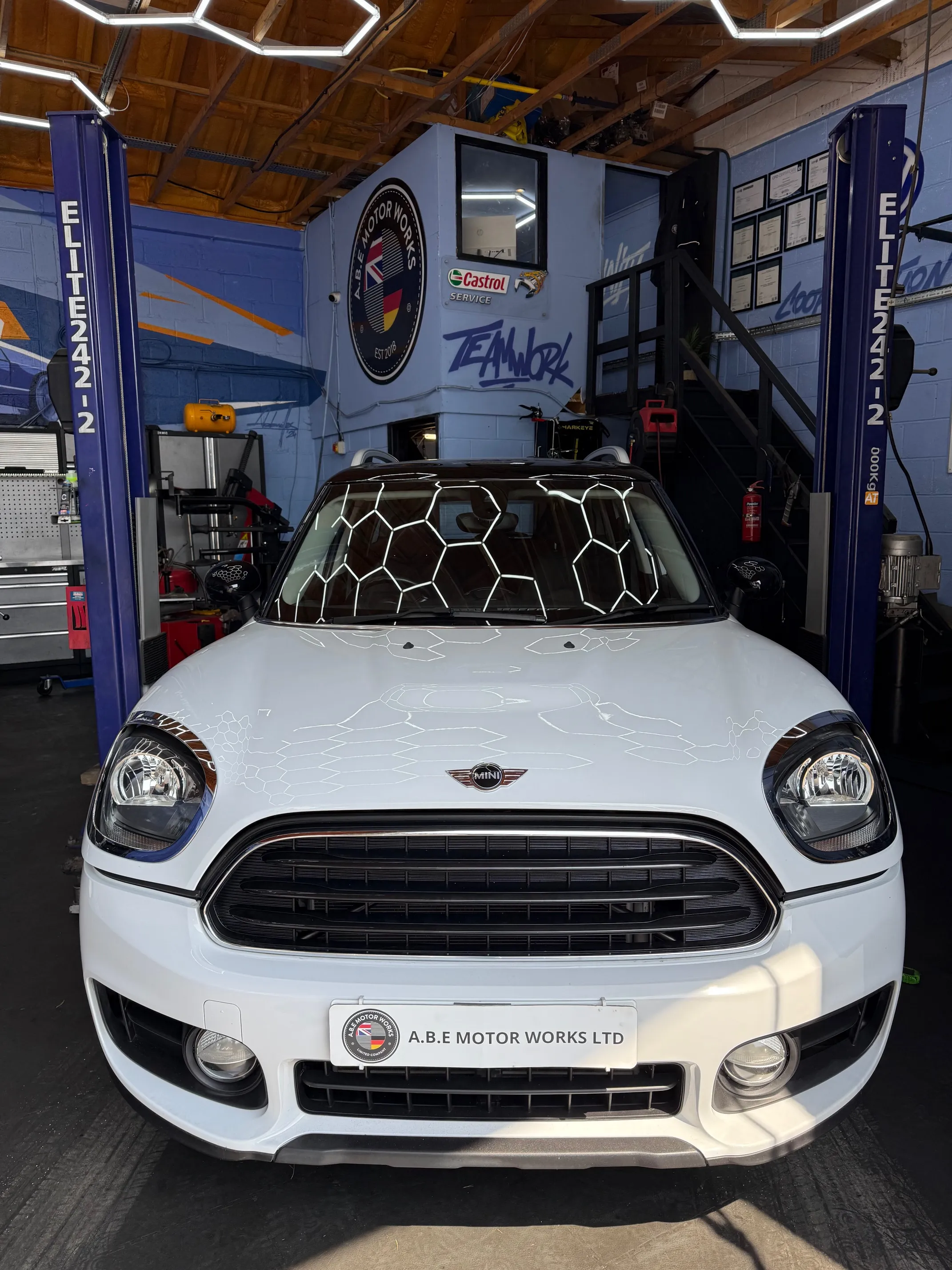 A white car parked inside of a garage.
