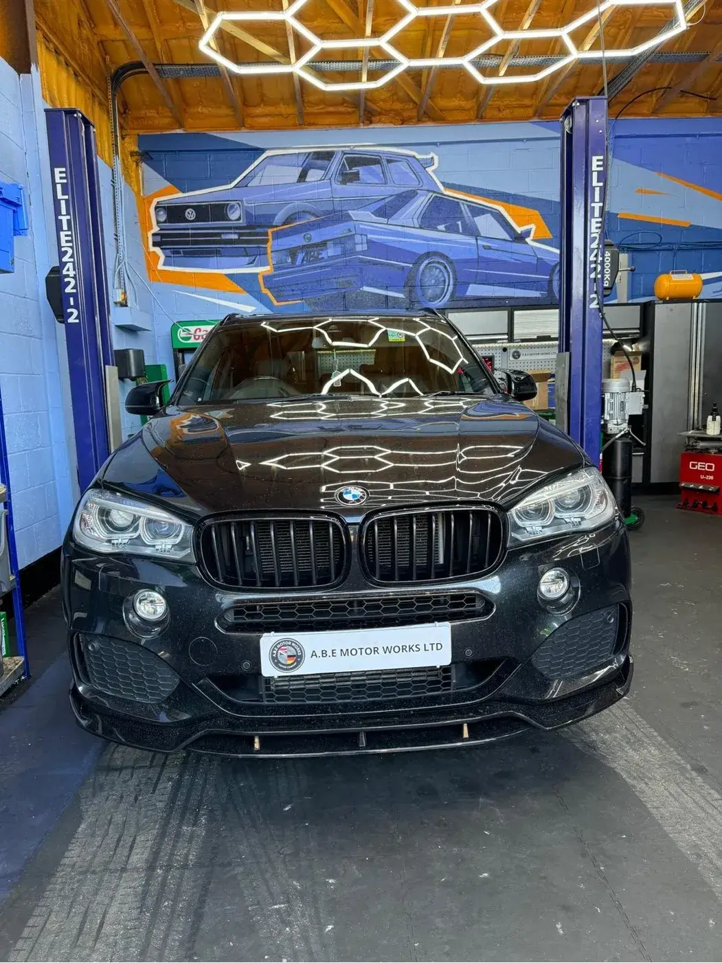 bmw x5 with a black paint job in a garage
