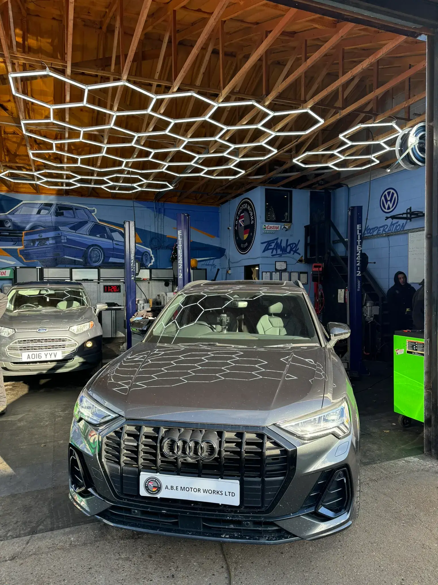 A silver car is parked in a garage.