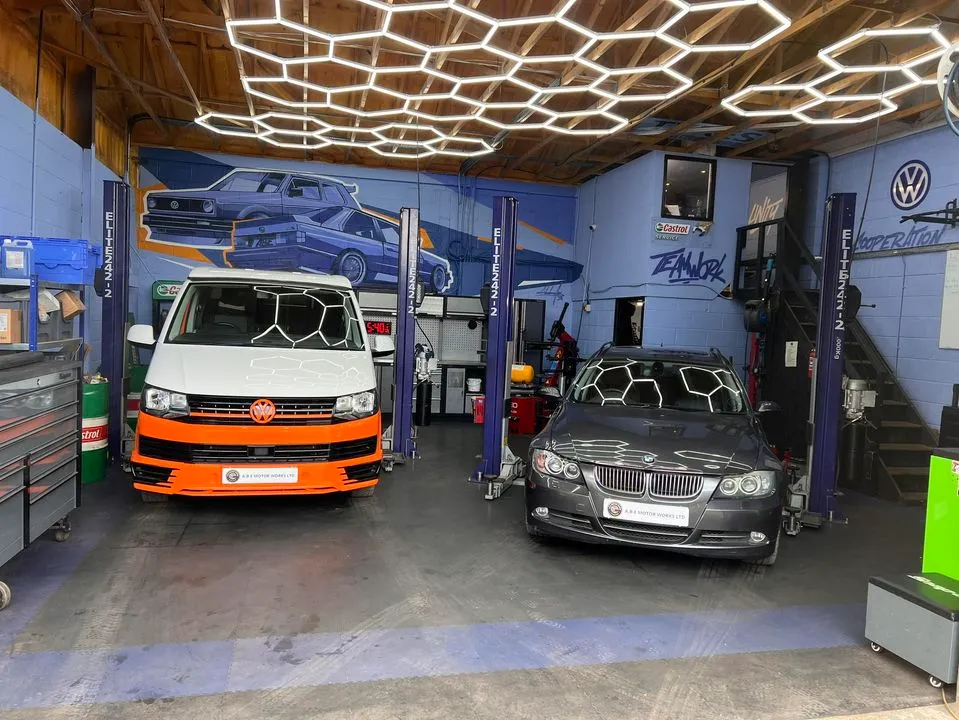 A garage with two cars parked in it.