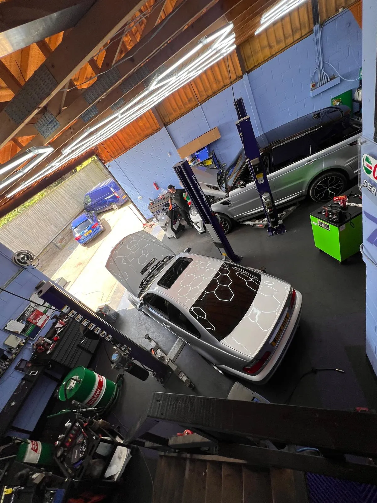A garage with several cars parked in it.